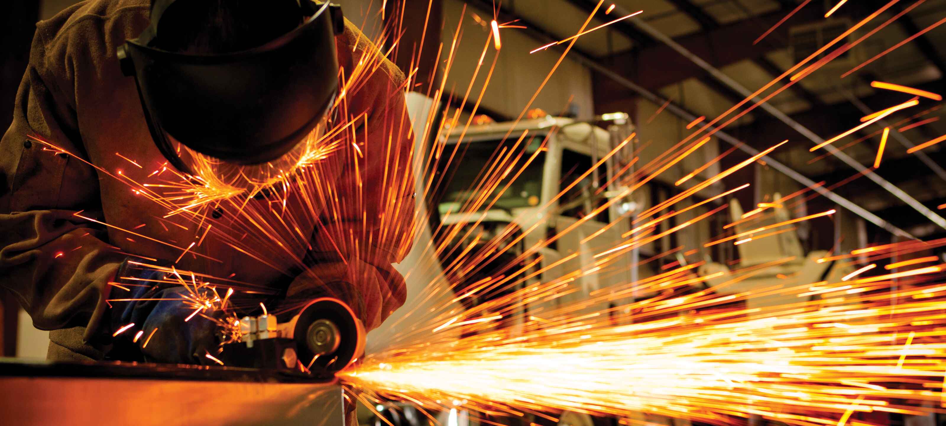 Technician welding part with sparks flying