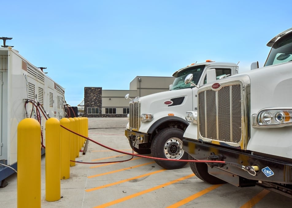 Close up of two Peterbilt trucks being filled up with CNG fuel
