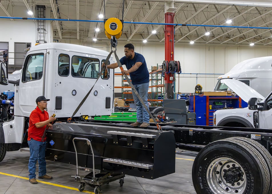 Two Custom Vehicle Solutions Technician attaching CNG Fuel tank to lift hook
