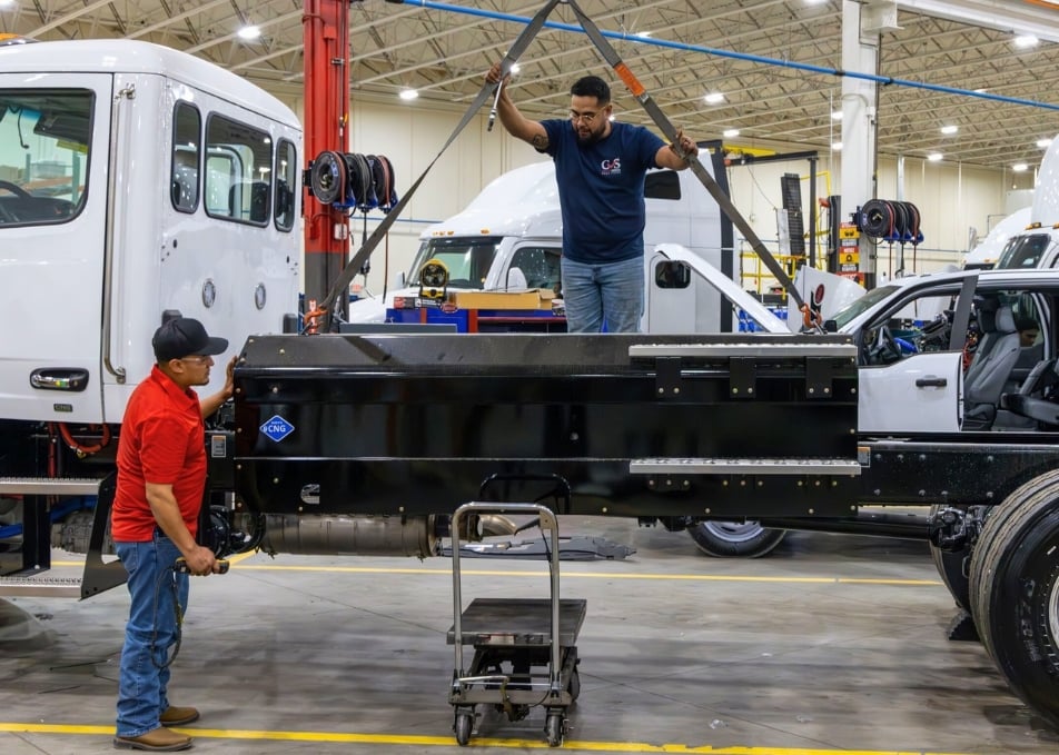 Three Custom Vehicle Solutions Technician lifting CNG Fuel tank with lift hook