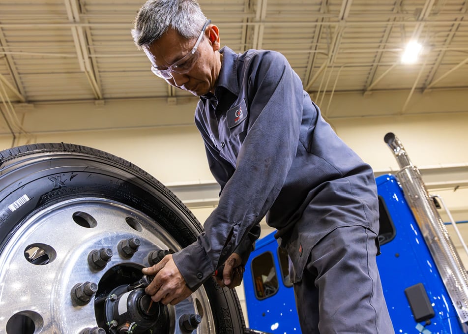 Close up of technician working on truck wheel