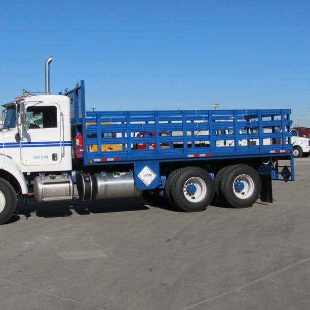 Side view of blue stake bed truck