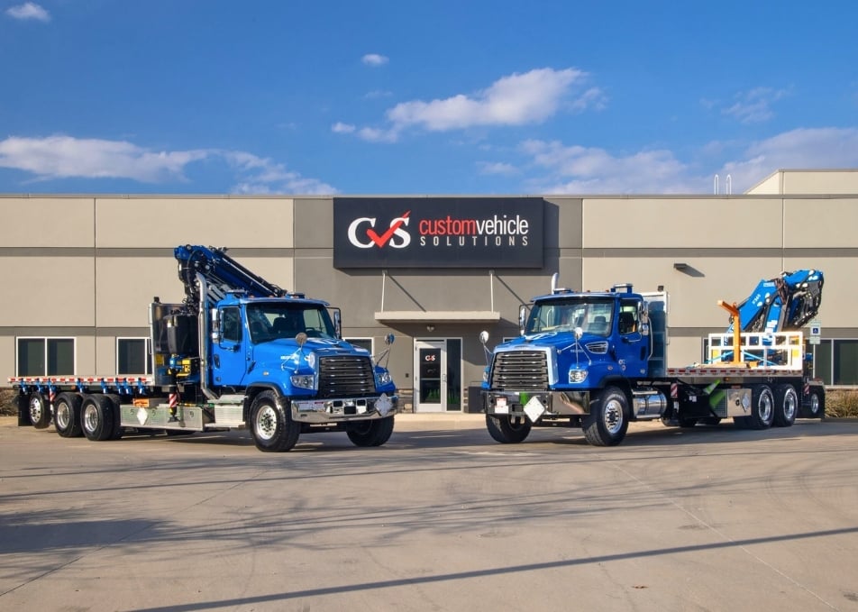 Two blue Peterbilt trucks with Fassi knuckle cranes