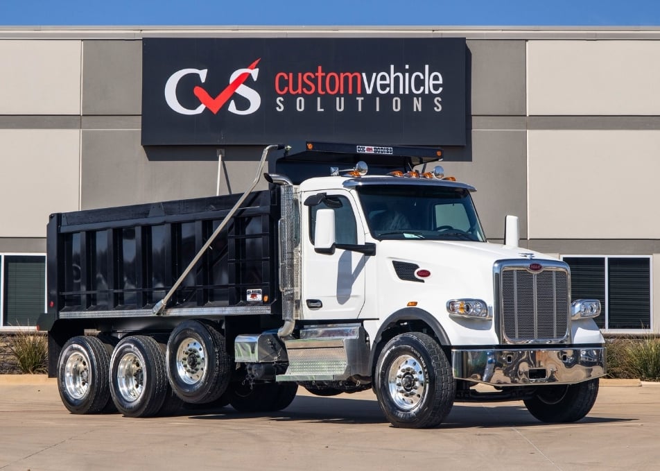 White Peterbilt truck with black Ox Bodies dump truck