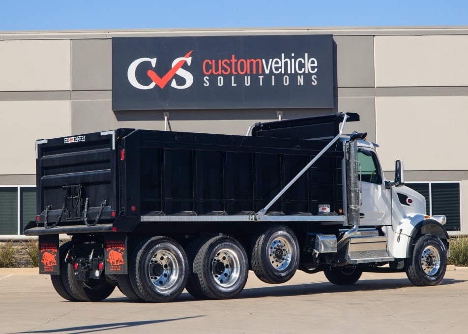 White Peterbilt truck with black Ox Bodies dump truck