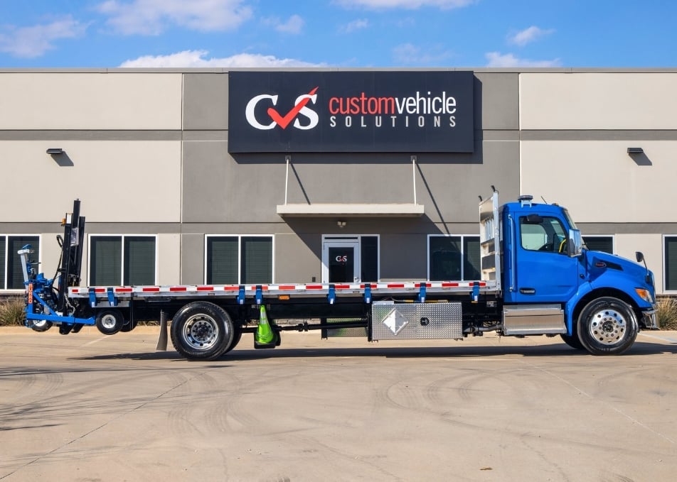 Blue Peterbilt truck with flatbed body with tool rack installed on back