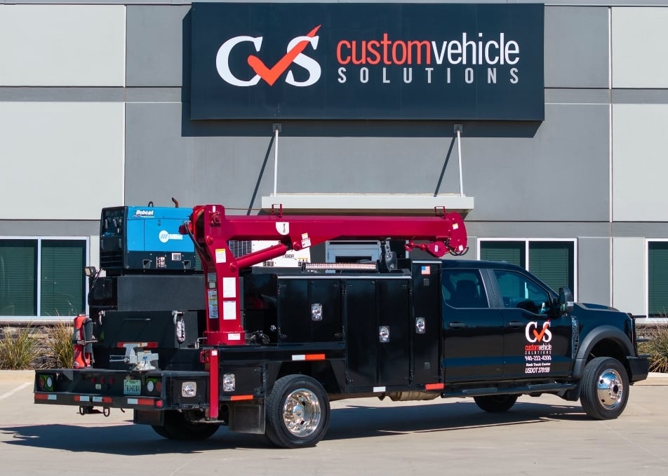 Back view of black Ford truck with black mechanics truck body with red crane