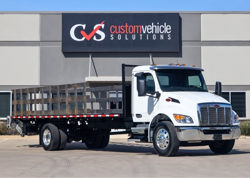 White Peterbilt truck with stake bed body