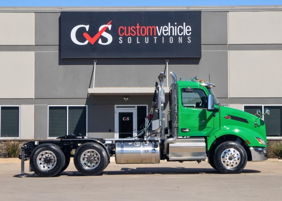 Side view of green Peterbilt truck with winch truck body