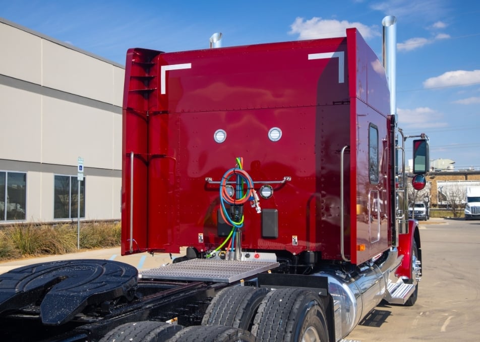 Peterbilt sleeper cab with winch body and aerodynamic side fairings and hydraulic wet line kit