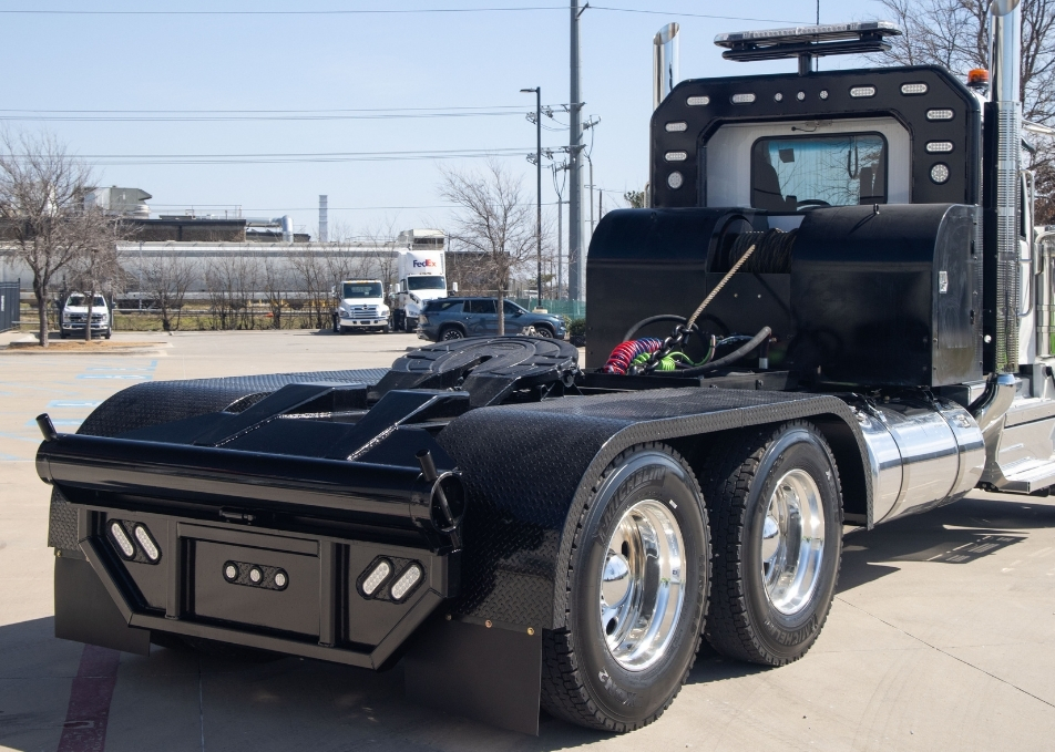 Winch truck body with custom fenders and headache rack with warning light