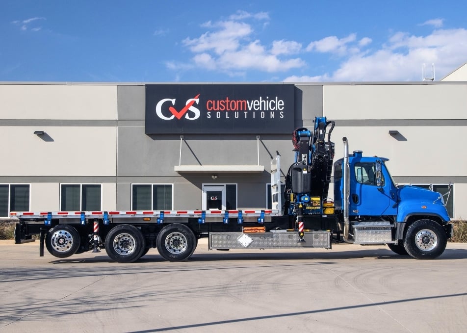Side view of flatbed truck with Fassi knuckle boom crane installed behind the cab