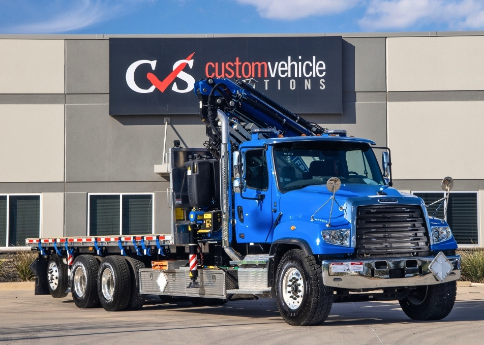 Front view of flatbed truck with Fassi knuckle boom crane behind the cab