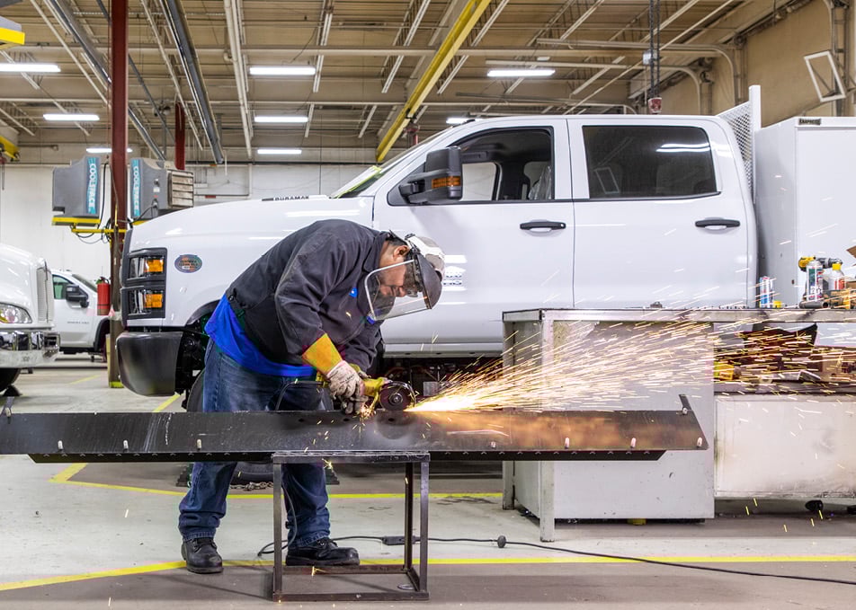 Technician welding a piece of truck frame