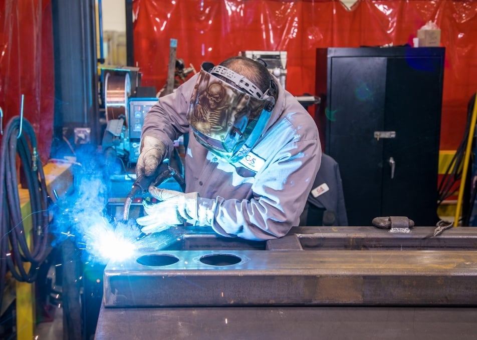 Technician working on truck frame on work bench