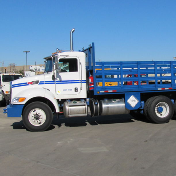 Side view of blue stake bed truck