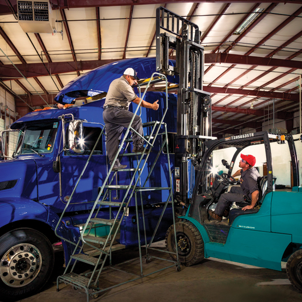 Techs installing air fairing on heavy-duty truck