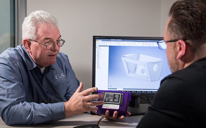 Custom Vehicle Solutions employee showing design mockup on computer screen to a customer