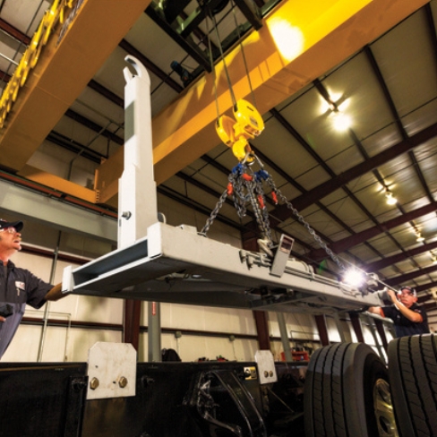 Tech installing truck body with hook lift