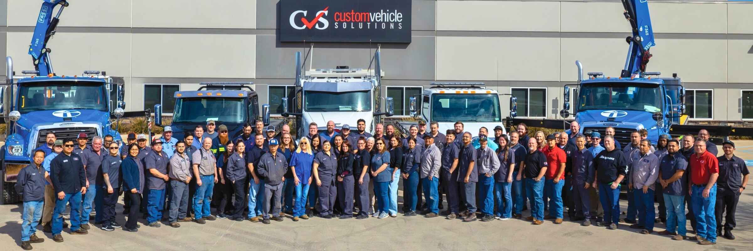 Custom Vehicle Solutions – Denton employees in front of row of trucks