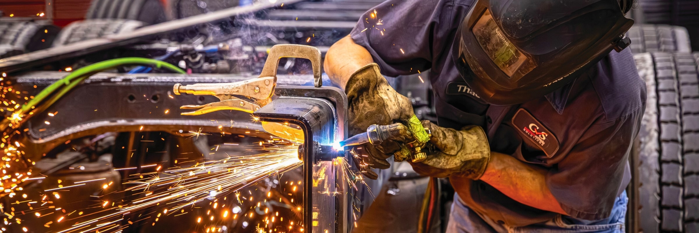 Close up of technician welding part of truck frame
