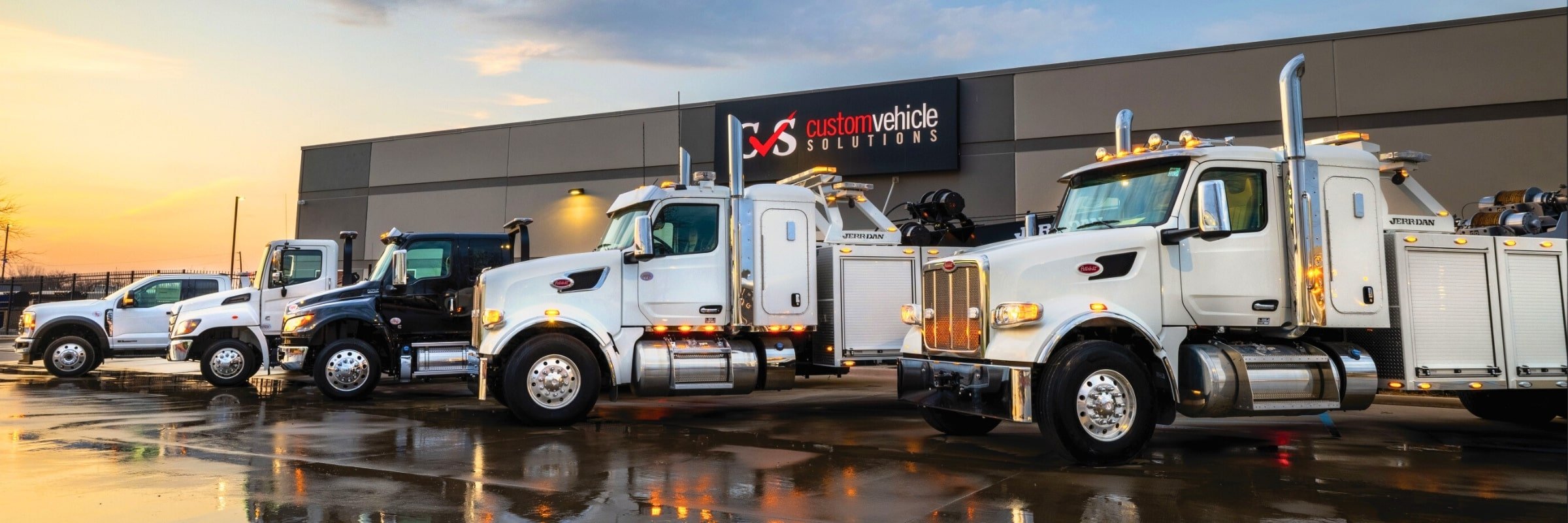 Line up of tow trucks outside Custom Vehicle Solutions - Denton