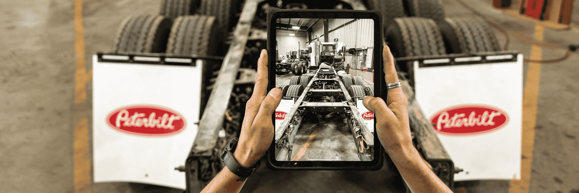 View of technician taking photo of Peterbilt truck chassis on tablet